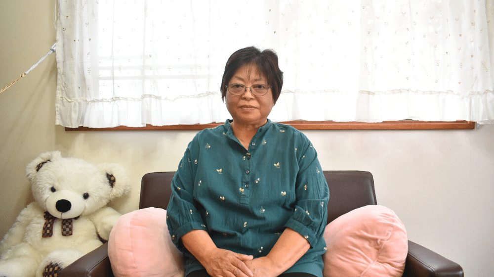 弘美さんがソファーに座って真剣に話そうとされている姿